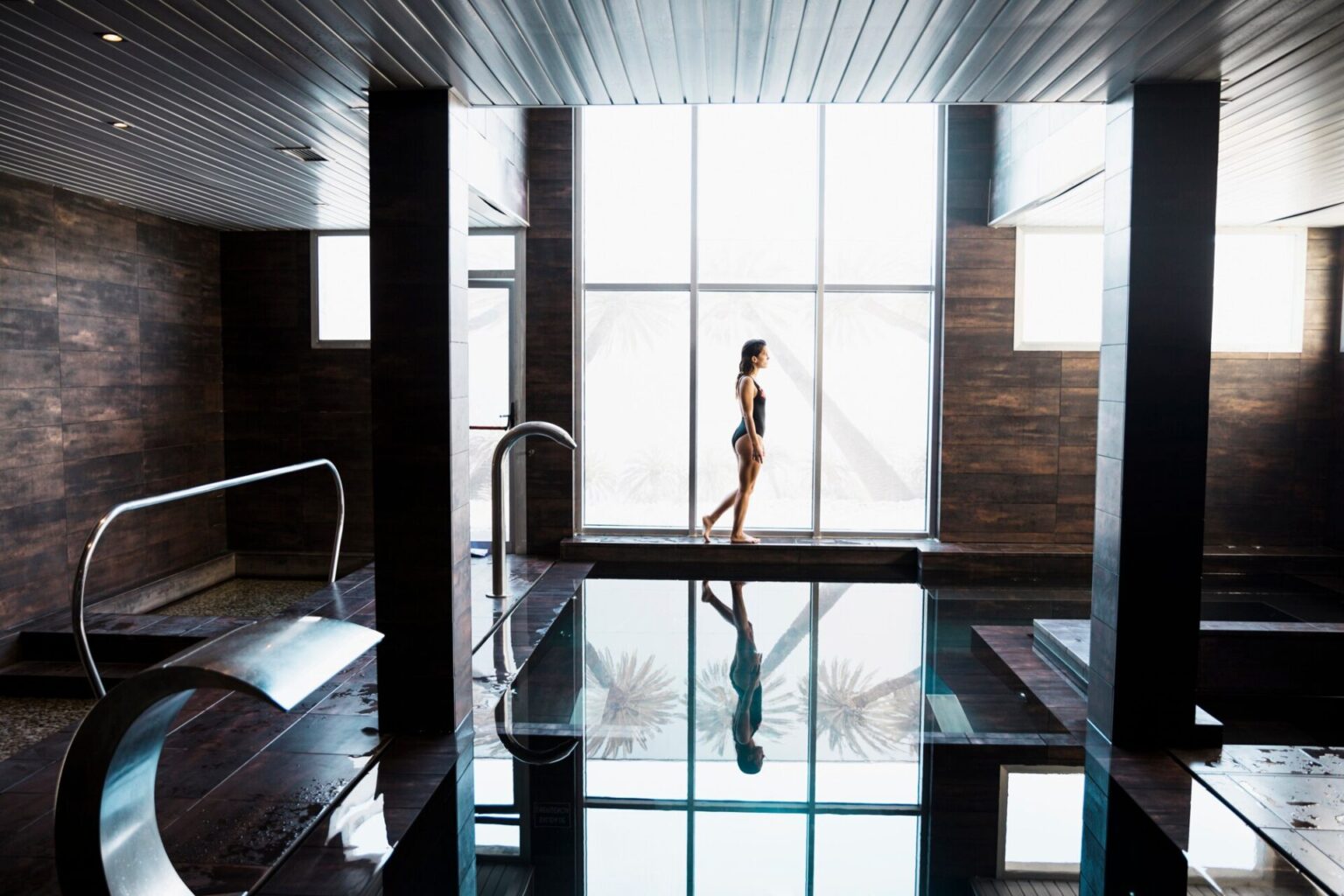 Woman moving from infrared sauna to swimming pool